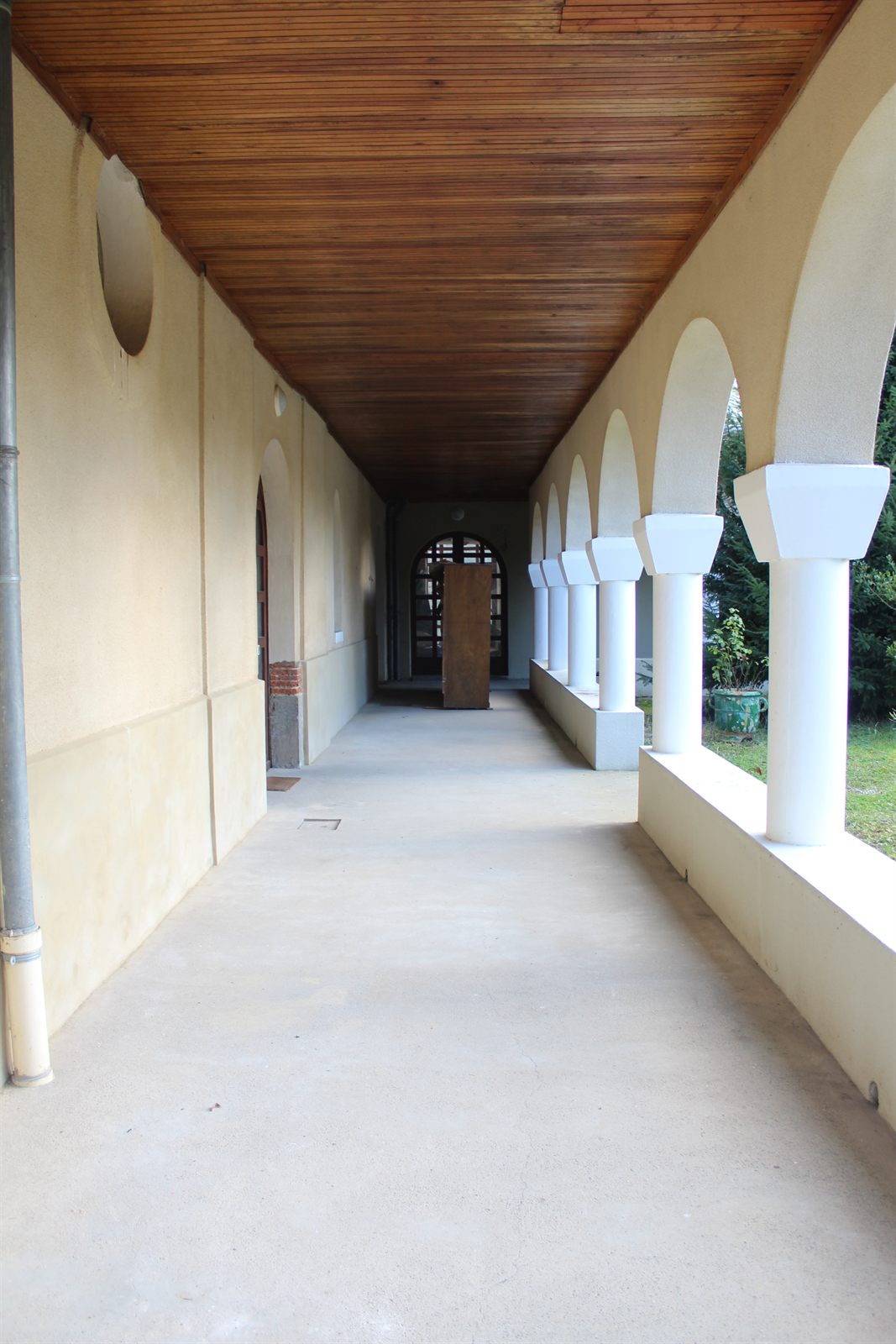 A long vaulted gallery with brick arches, lit from a series of windows down one side.