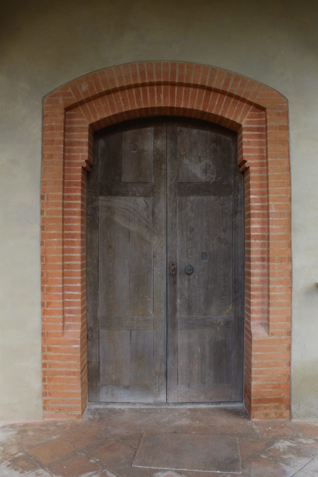 A tall timber door in a stone surround with iron fittings.